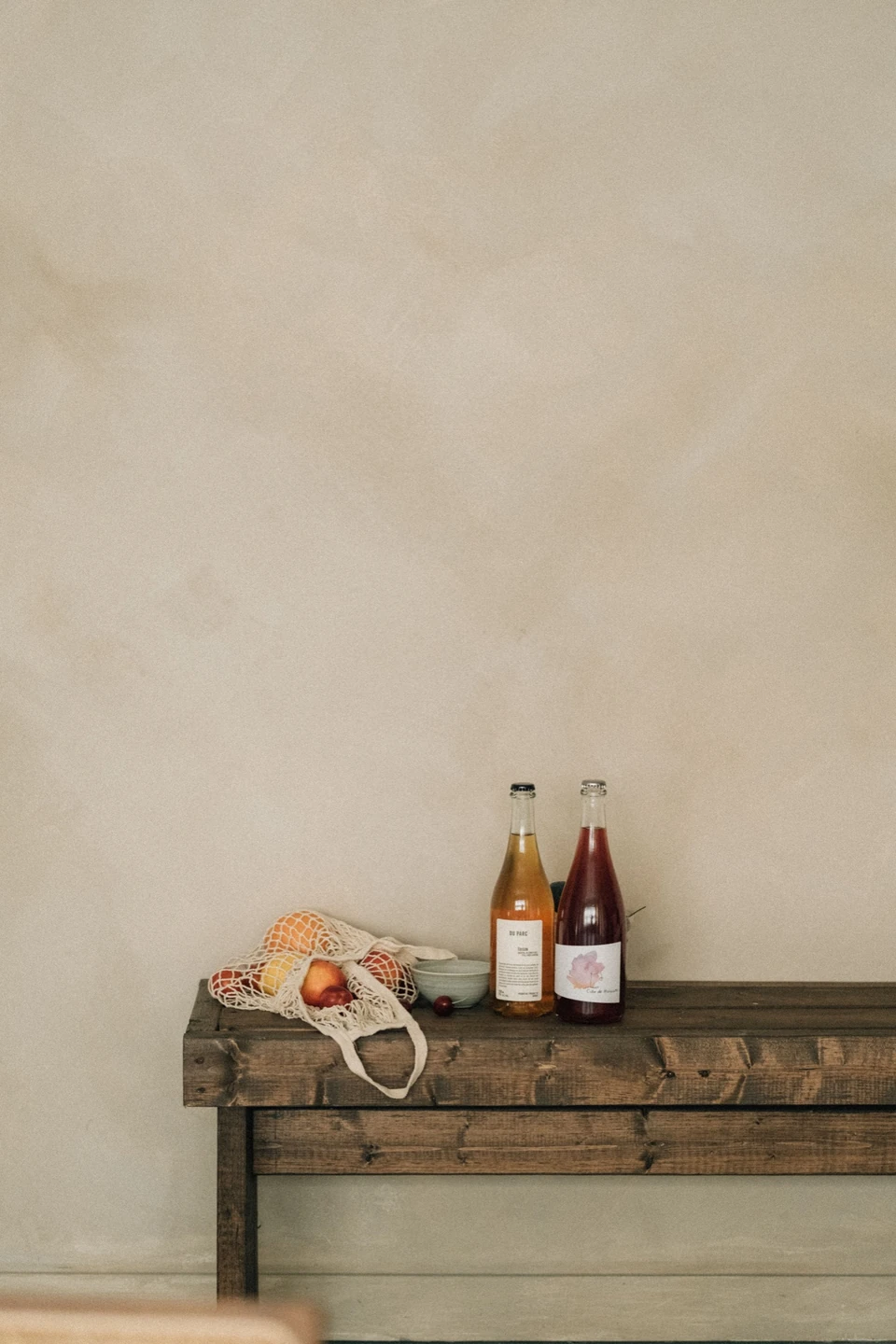 Nature morte minimaliste avec bouteilles, fruits et matières naturelles